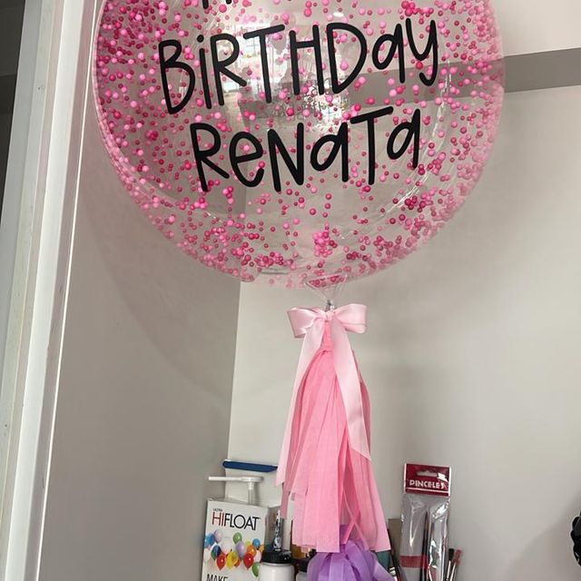 Globo burbuja transparente con confeti rosa estilo nieve y mensaje personalizado, hecho por Globo Soph